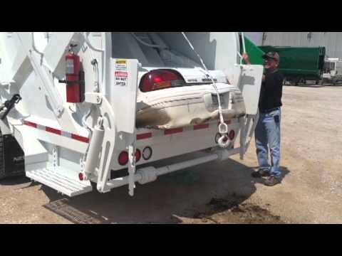 Un camion poubelle avale une voiture