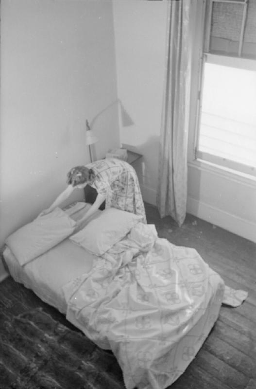 Mrs Olive Day fait son lit qu a été déplacé au rez de chaussée, l'étage étant trop dangereux.