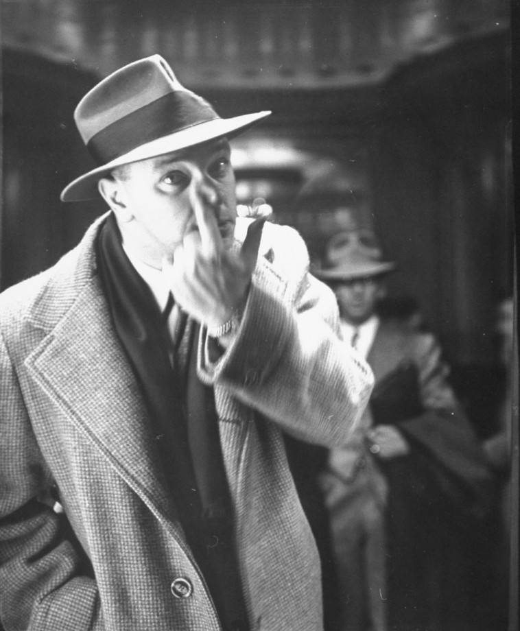 Man looking closely at side of nose in front of tr