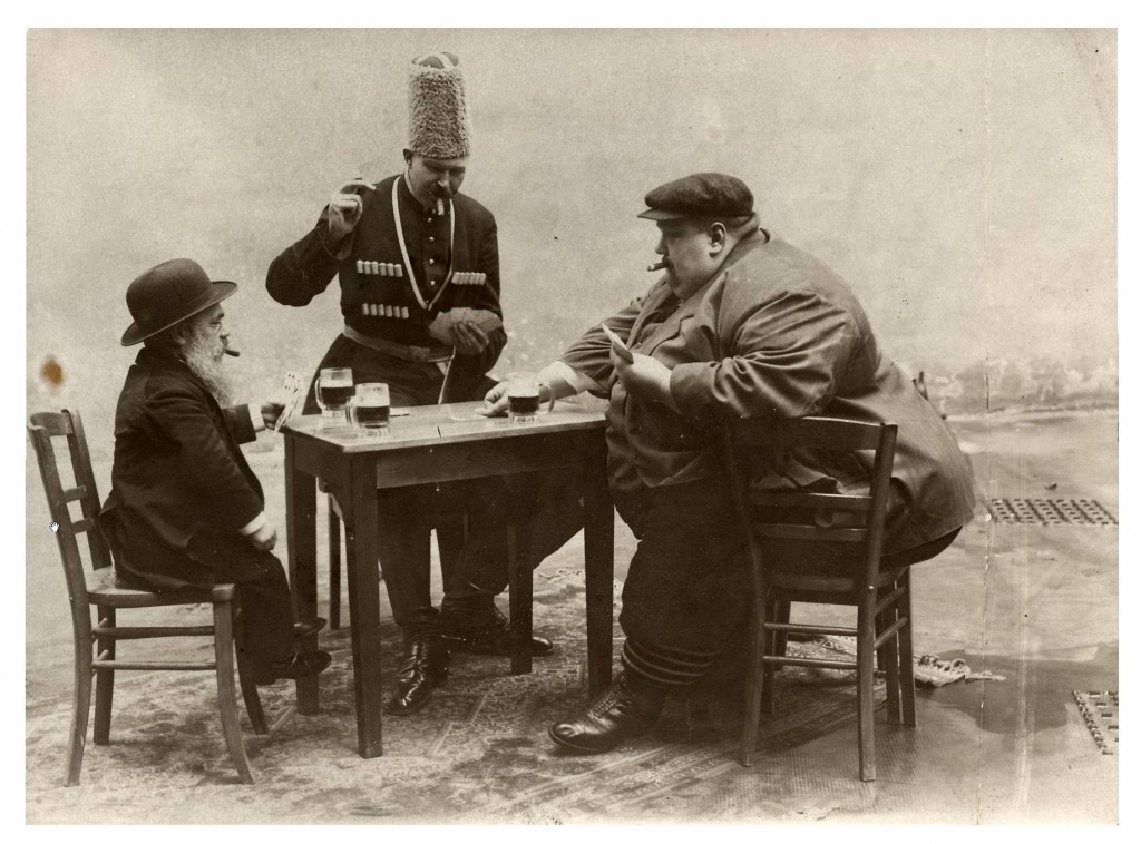 Un petit, un grand, et un gros jouent aux cartes en 1913