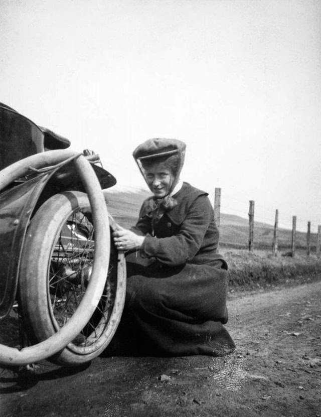 Une femme change la roue de sa voiture en 1926