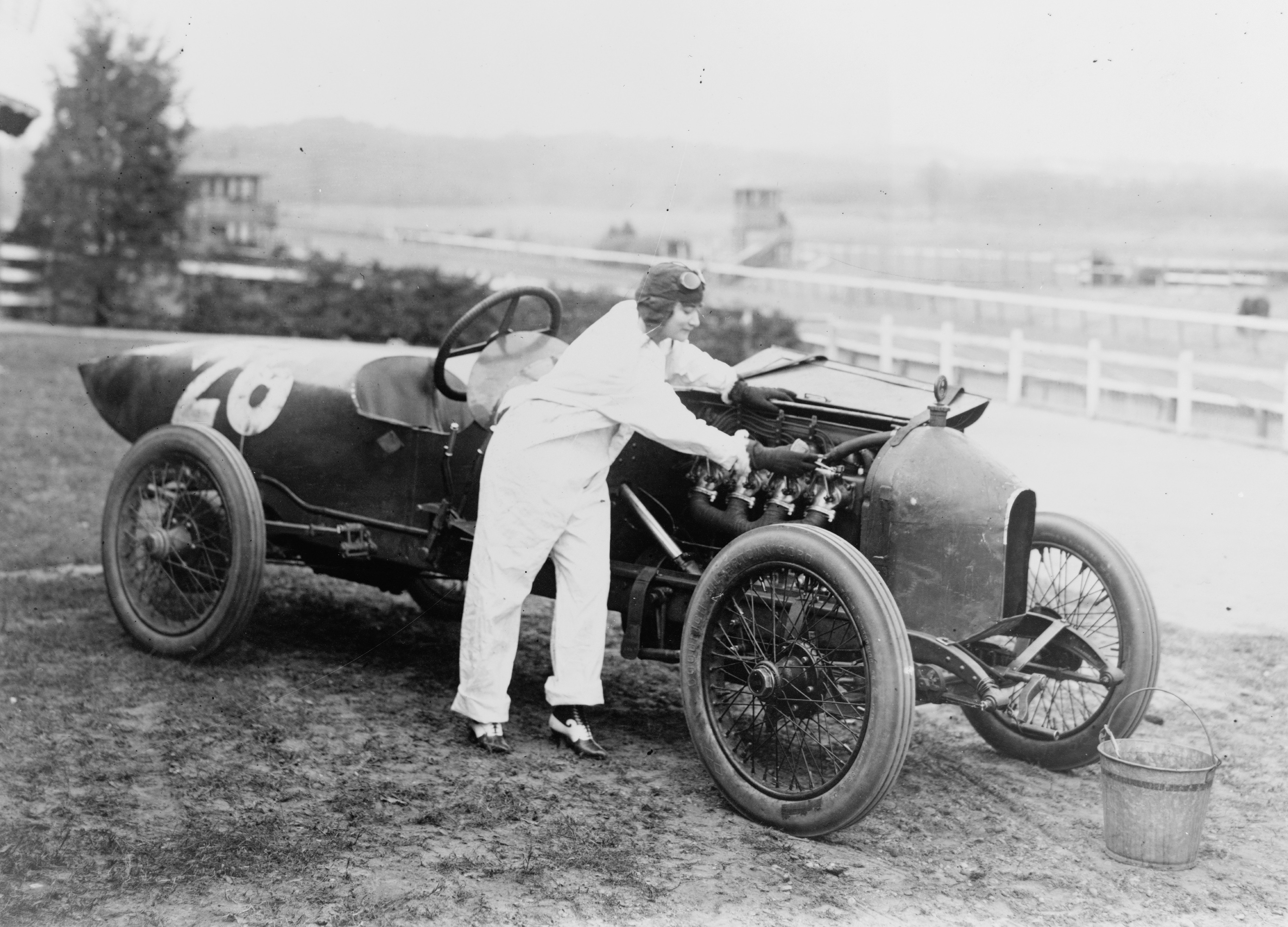 Une femme travaille sur une voiture de course juste avant le départ – 1916