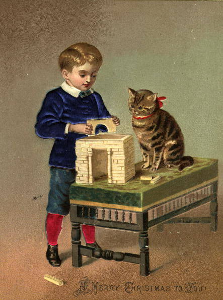 circa 1885: A Christmas greetings card showing a boy playing with building bricks, and a cat looking on. (Photo by Hulton Archive/Getty Images)