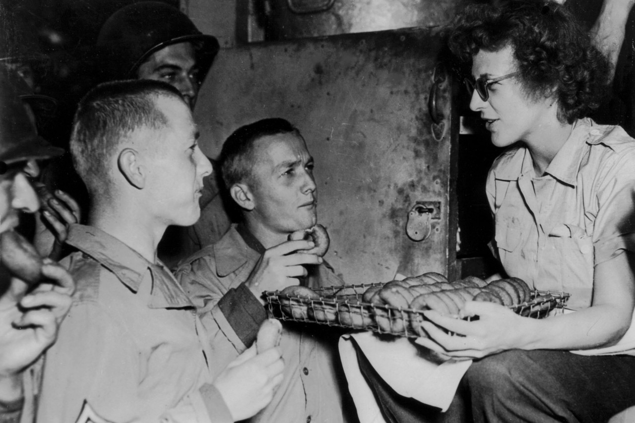 Two American soldiers , who are brothers, sample doughnuts offered by a member of an American red Cross clubmobile in Normandy (Summer 1944). (Photo by Photo12/UIG/Getty Images)