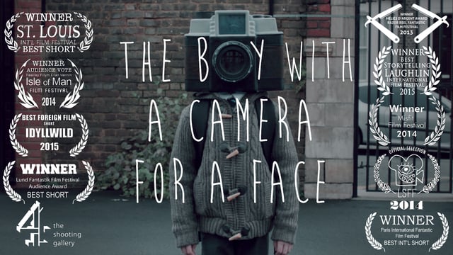 Le garçon avec une tête d’appareil photo